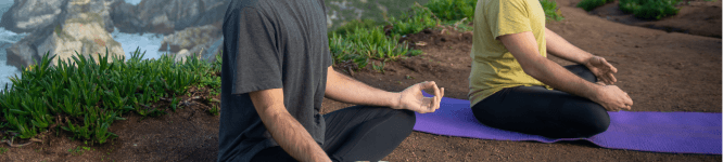 two people meditating in a mat